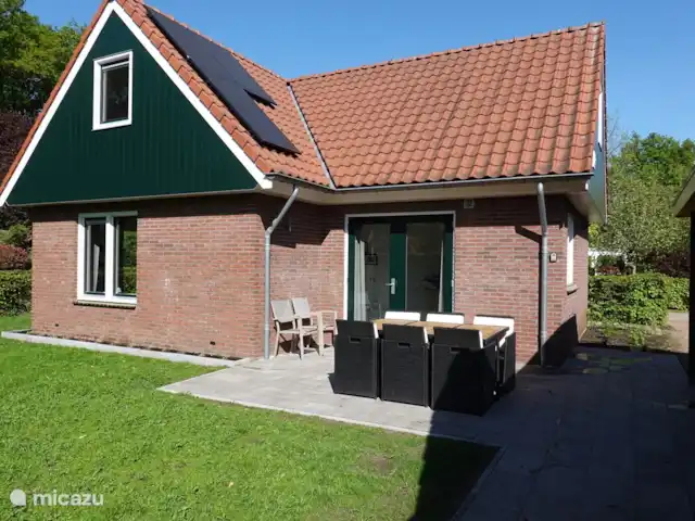 Een ruime tuin met een zonnig terras
